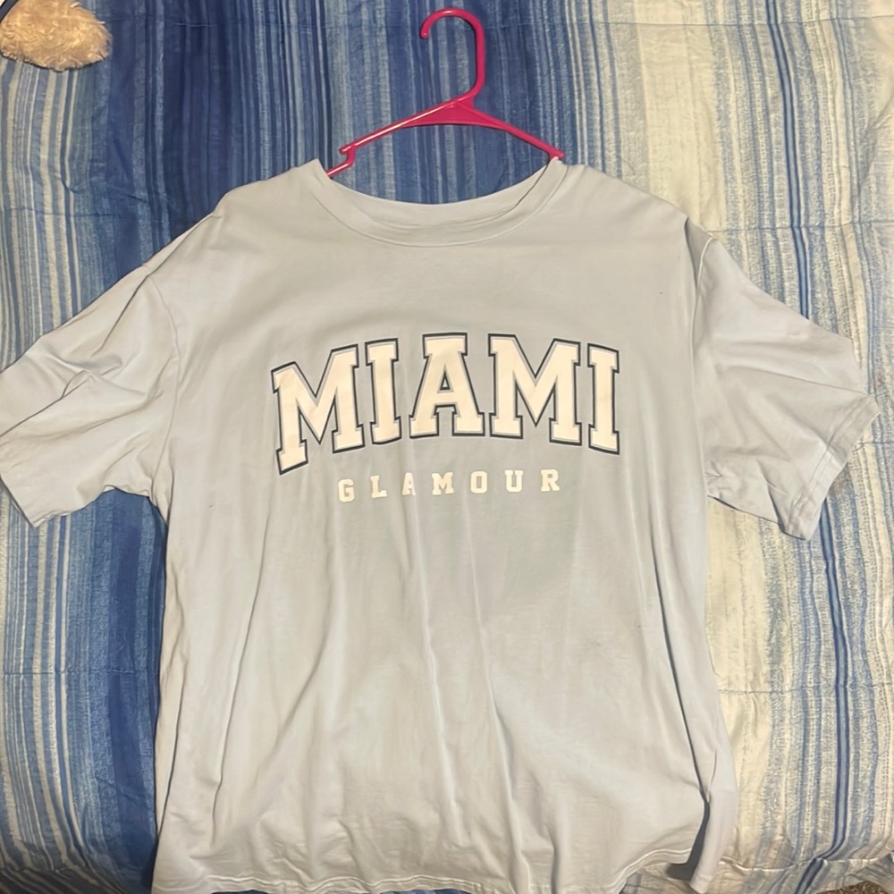 Selling a medium sized shirt with white bold Miami across it and baby blue shirt